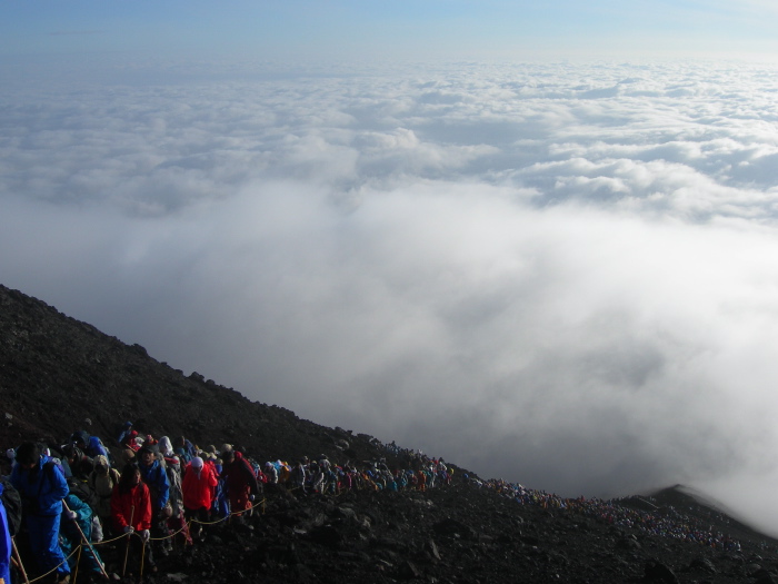 File ininterrompue d'escaladeurs au sortir des nuages