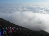 Uninterrupted line of climbers leaving the clouds